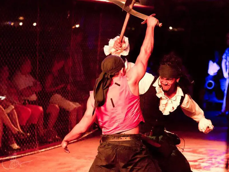 Two pirates sword fighting as part of the show