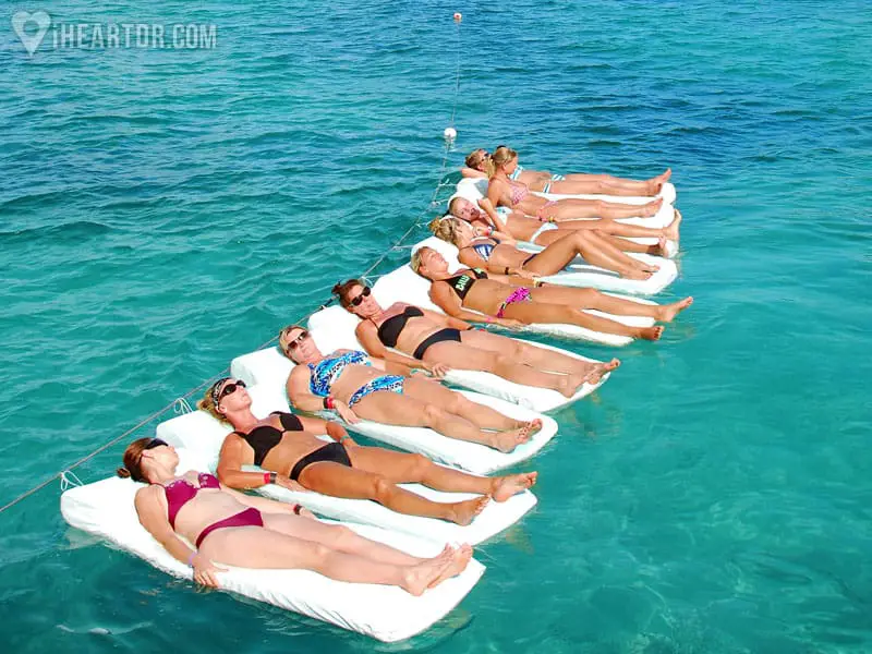 Women lying on floating mattresses in the ocean