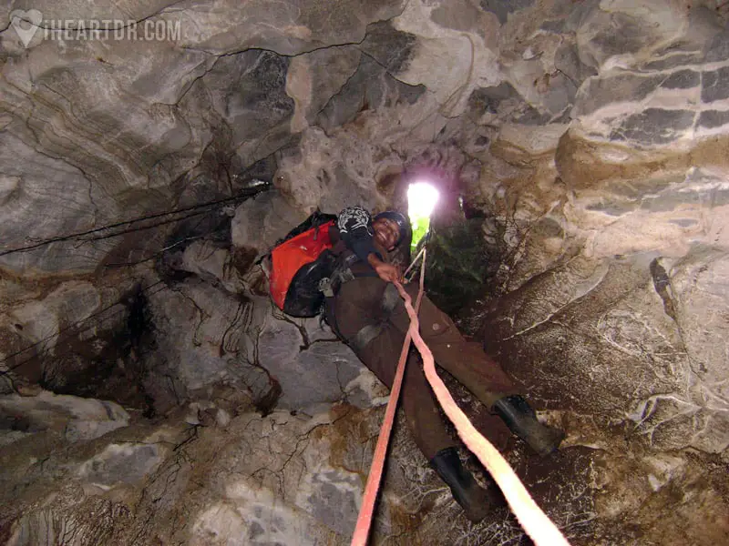 Man rappelling down into the cave