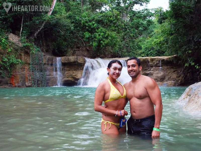Couple posing for the camera in a small waterfall