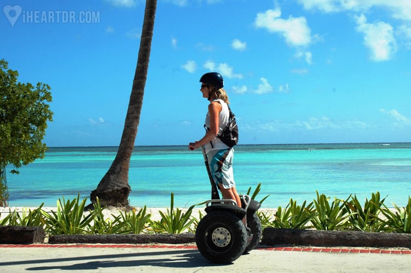 Woman riding her segway with the beach as background