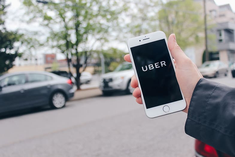 hand holding a cellphone and the uber logo is on the screen
